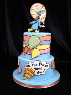 a blue cake with an image of the cat in the hat and balloon on top