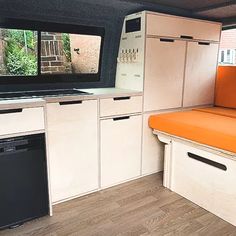 a kitchen with an orange seat and white cabinets