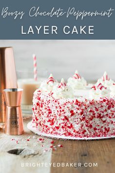 a red velvet layer cake with white frosting and sprinkles