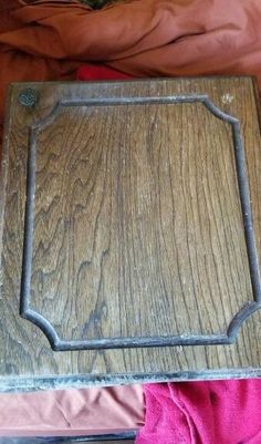 an old wooden table with metal trim around the edges, and a pink blanket on top