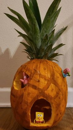 a pineapple shaped like a house with figurines inside