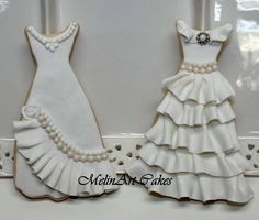 two decorated cookies in the shape of wedding gowns