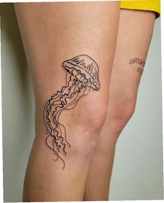 a woman's legs with a tattoo of a jellyfish on the side and words written in black ink