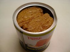 an open can of tuna on a white table