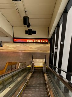 an escalator in a building with black and white striped walls