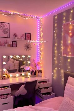 a bedroom decorated in pink and purple with fairy lights on the wall above the desk