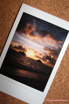 an image of a sunset taken from the beach with a polaroid frame on top