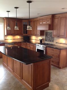 a kitchen with wooden cabinets and black counter tops