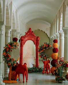 an elaborate entrance decorated with flowers and fake deers in front of a large mirror