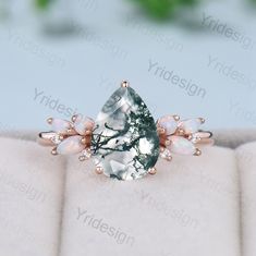 an image of a ring with opal stones and leaves on the side in pink gold