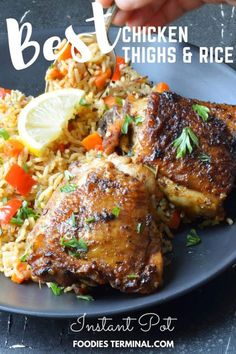 chicken thighs and rice on a plate with lemon wedges, carrots and parsley