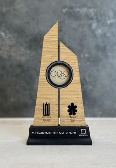 a wooden trophy with the olympic logo on it