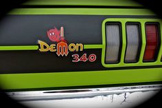 the front end of a green and black car with demon stickers on it