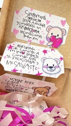 two boxes filled with pink paper and some writing on the inside of each box are decorated with teddy bears