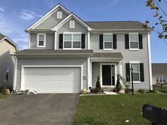 a two story house with white trim and black shutters on the front door is shown