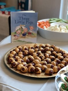 there is a plate of food on the table next to a book and bowl of vegetables