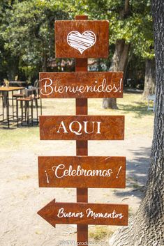 a wooden sign pointing to different places in the park with words written on it and an image of a heart