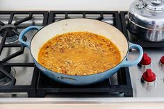 a blue pot filled with food sitting on top of a stove