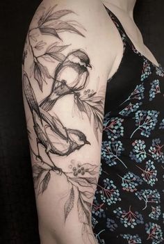 a woman's arm is covered in tattoos and has an image of birds on it