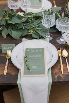 the table is set with green and white plates, silverware, and napkins