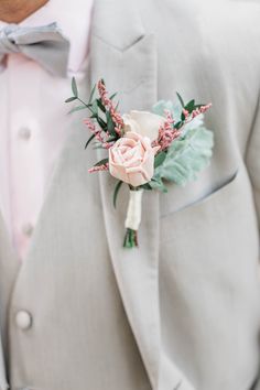 a man in a gray suit with a pink rose boutonniere