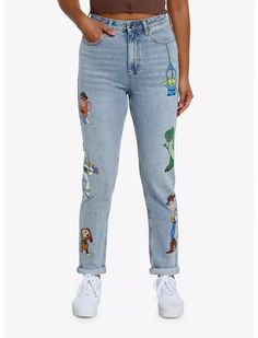 a woman wearing jeans with cartoon characters on them