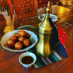 some food is sitting on a table next to a tea pot