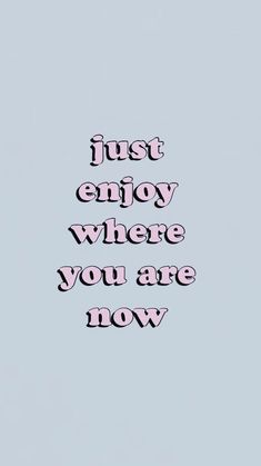 the words just enjoy where you are now written in pink on a light blue background