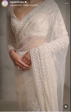 a woman wearing a white sari with sequins on it