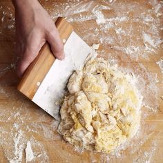 a person using a knife to cut up dough