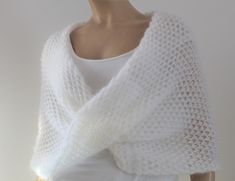 a white knitted shawl draped over a mannequin