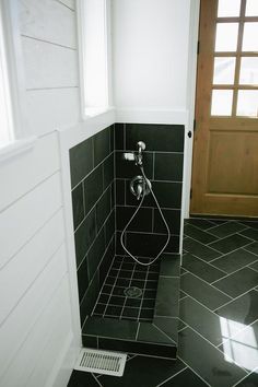 a black and white tiled bathroom with a toilet in the corner, next to a window