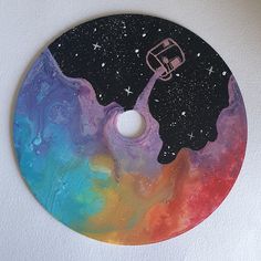 a painting on a white wall with a colorful disc