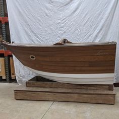 a wooden boat on display in a warehouse