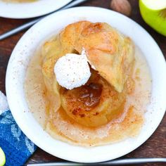 two white plates topped with pancakes covered in powdered sugar next to sliced green apples