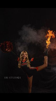 a woman in a cheerleader outfit is holding fire