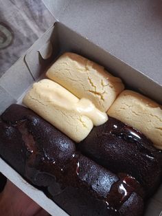 a box filled with different types of pastries on top of each other in it