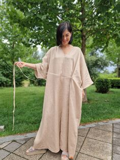 Experience unmatched comfort and stylish design with the Linen Kimono Oversized Dress - Morkva Dune. Crafted from 100% organic linen, this dress is perfect for any body type, thanks to its uniquely wide cut. The design of this dress is inspired by traditional Japanese kimonos and the iconic characters from the film "Dune", traveling across vast deserts. This combination gives the dress a distinctive character, making it a true masterpiece in the world of fashion. The Morkva Dune Kimono Dress will not only amaze everyone with its extraordinary appearance but also provide you with incredible comfort. The natural linen and loose fit create a lightweight, breathable garment, ideal for warm weather. Discover the perfect blend of style and comfort with the Morkva Dune Dress and become the center Spring Linen V-neck Kaftan, Oversized Linen Maxi Dress, Oversized Linen V-neck Maxi Dress, Oversized Linen Maxi Dress With V-neck, Oversized Linen V-neck Dress, Oversized Beige Lagenlook Dress, Elegant Linen Kaftan For Summer, Long Linen Kaftan, Relaxed Fit Linen Maxi Dress Tunic