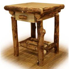 a small wooden table with logs on the bottom and one drawer at the top, sitting on a hard wood floor