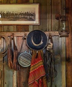 there is a cowboy hat and other items hanging on the wall in front of it