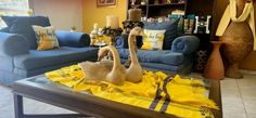 two birds sitting on top of a table in front of a couch and coffee table