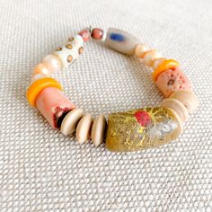 Peach, yellow, and neutral colored sustainable bead bracelet. African prayer bead in Light Tan, peach coral, rosewood, and peach freshwater pearls. Measures 7-8”, size regular (M-L) Sterling silver BelleStyle logo tag. Prayer bead symbolize health, love, good fortune and loyalty. One of a kind. Comes in linen travel pouch. Made in USA. Handmade Peach Bracelets With Round Beads, Handmade Peach Beaded Bracelets As Gift, Handmade Peach Beaded Bracelets For Gift, Artisan Orange Bracelets With Colorful Beads, Artisan Orange Bracelet With Colorful Beads, Artisan Orange Hand-strung Beaded Bracelets, Bohemian Peach Bracelets For Gifts, Bohemian Peach Bracelets For Gift, Peach Bohemian Bracelet For Gifts