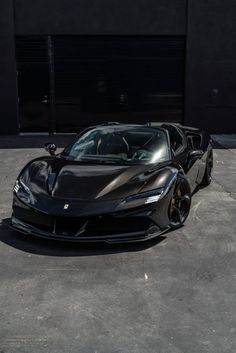 a black sports car parked in front of a garage