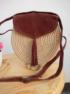 Moroccan Raffia bag is handwoven by local artisans, Raffia woman bag will be irreplaceable accessory very elegant and combines with different style. that round raffia and leather handbag have slight imperfections and shape. Made: Handmade in Morocco Materials: Raffia Palm Leaves & adjustable leather strap Width 7.9 in / 20 cm approx Height 7.9 in / 20 cm approx Depth 2.4 in / 6 cm approx Raffia Palm, African Hats, Woman Bag, Round Bag, Boho Patterns, Leather Ottoman, Raffia Bag, Top Handle Bags, Boho Bag