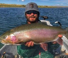 a man in a boat holding a large fish