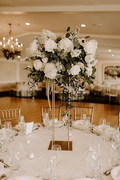 a centerpiece with white flowers on top of a table