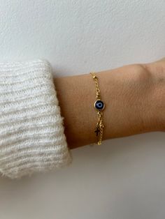 Brush away negative energy and stay protected with this dainty evil eye bracelet! D E T A I L S *It features a gold filled evil eye charm (12 x 6.5mm) in traditional blue *on a high quality 18k gold filled chain in yellow gold. *Gold filled is a wonderful alternative to solid gold and unlike gold plating does not rub off. *A tiny gold filled cross dangles from the chain. *It closes with a hall marked gold filled spring clasp measuring 6mm. *Choose the length from the drop down menu. Use the length guide as a reference to help you get the right size. Bracelet needs to be snug to stop it rolling. C A R E * T I P :  To keep your bracelet in great condition avoid contact with water, perfume and chemicals. Also remove when exercising and sleeping . P A C K A G I N G: All our products are gift r Gold Spiritual Evil Eye Bracelet For Everyday, Everyday Yellow Gold Evil Eye Bracelets, Dainty Yellow Gold Bracelet With Evil Eye Detail, Dainty Yellow Gold Bracelet With Evil Eye, Gold Spiritual Evil Eye Bracelet With Adjustable Chain, Dainty Adjustable Gold Evil Eye Bracelet, Dainty Evil Eye Bracelet With Adjustable Chain, Gold Plated Evil Eye Bracelet, Dainty Gold Adjustable Evil Eye Bracelet