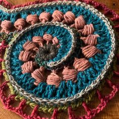 three crocheted coasters on top of a wooden table