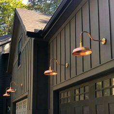 three lights are hanging from the side of a house