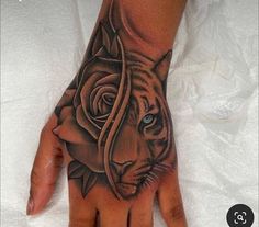 a hand with a tiger and rose tattoo on it